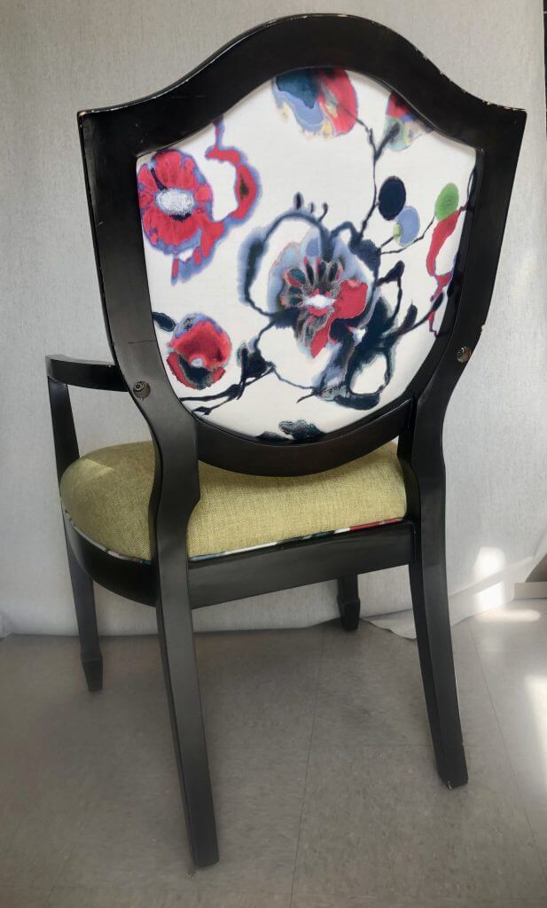 Chair with floral design on the back.