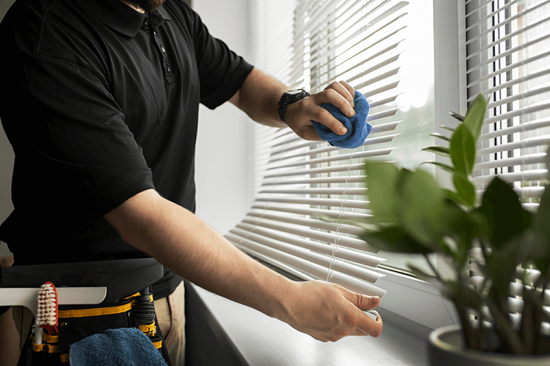 Ace Upholstery worker cleaning window blinds in a Halifax home.